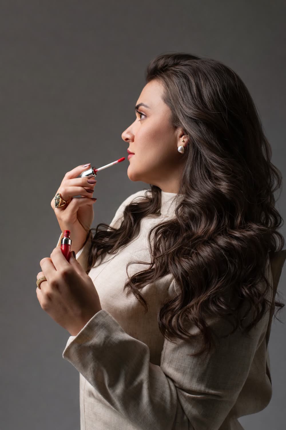 Bruna Patrícia de perfil aplicando batom vermelho
